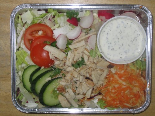 Salatplatte mit Gurke, Tomate, Radies, Putenstreifen und Dressing
