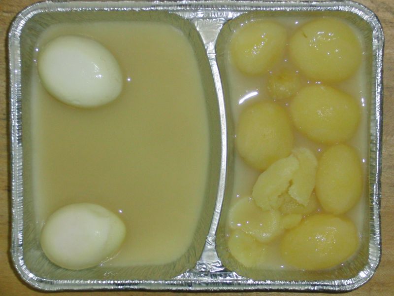 2 gekochte Eier in süß-saurer Soße, mit Möhren-Apfel-Salat und Salzkartoffeln